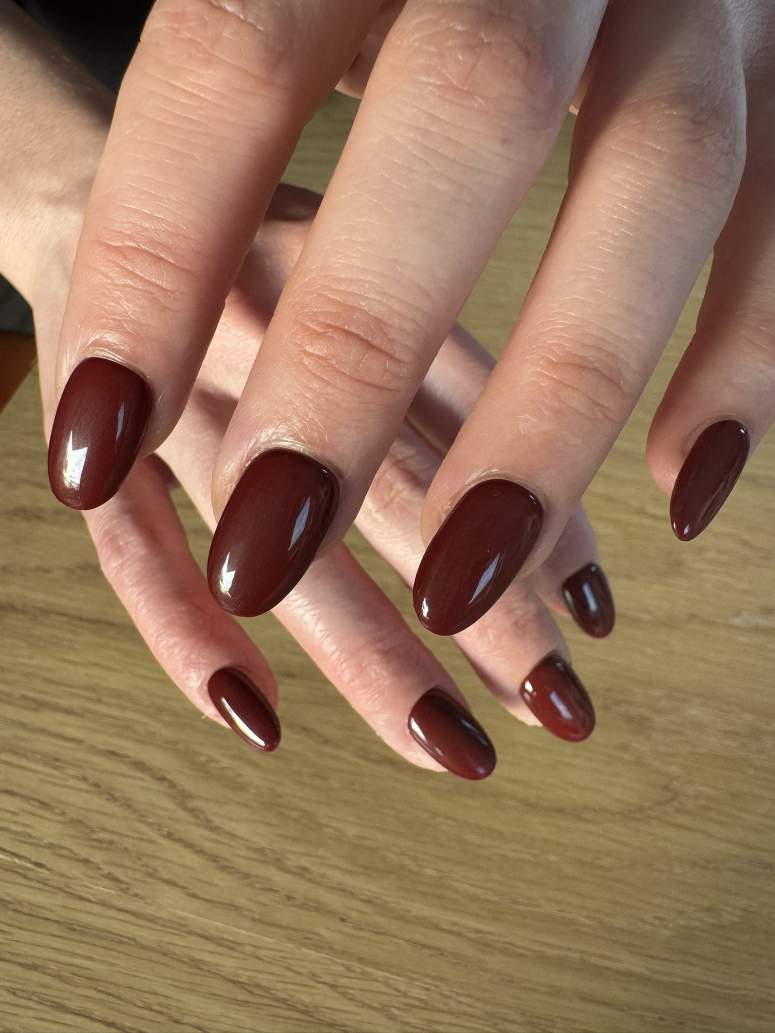 Ongles press-on HELVA rouge foncé portés par Aurelie de Lausanne